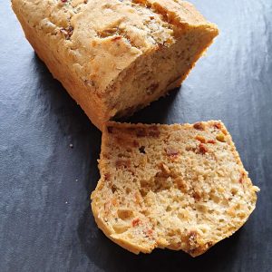 Ein frischens, aufgeschnittenes Kastenbrot mit Oliven und Tomanten im Brot